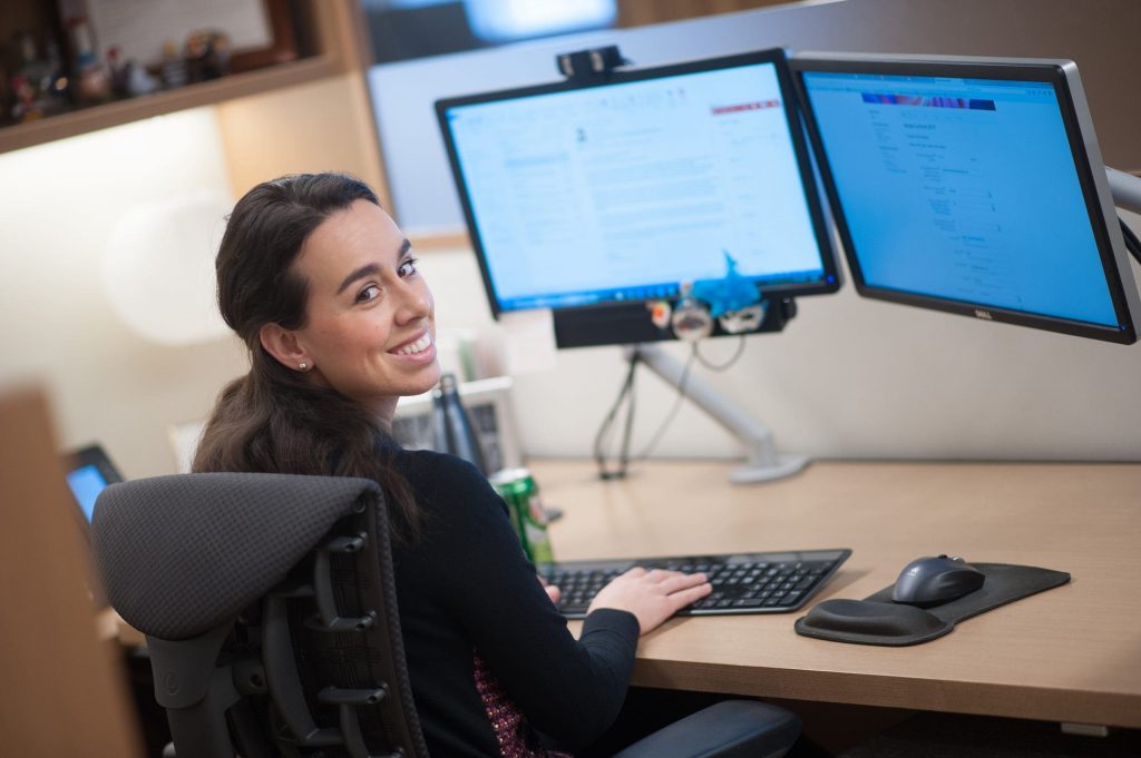 woman working at computer smiling at camera