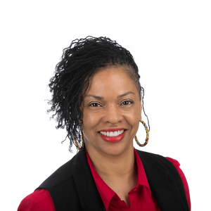 a black woman with gold earrings and black hair wearing a red blouse smiles at the camera