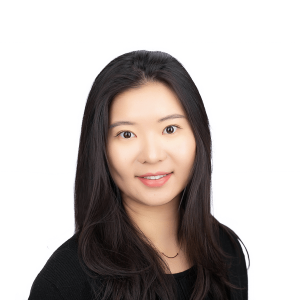 an asian woman with dark hair wearing a necklace wearing a black T-shirt and jacket smiles at the camera