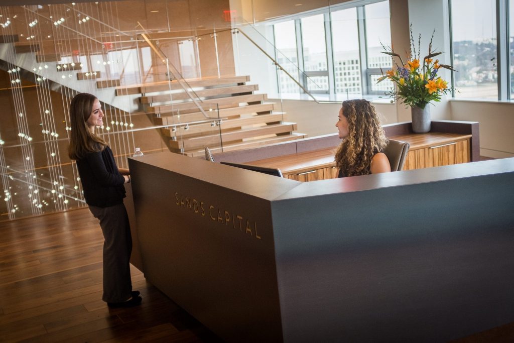the women are talking at the stand with the sands logo