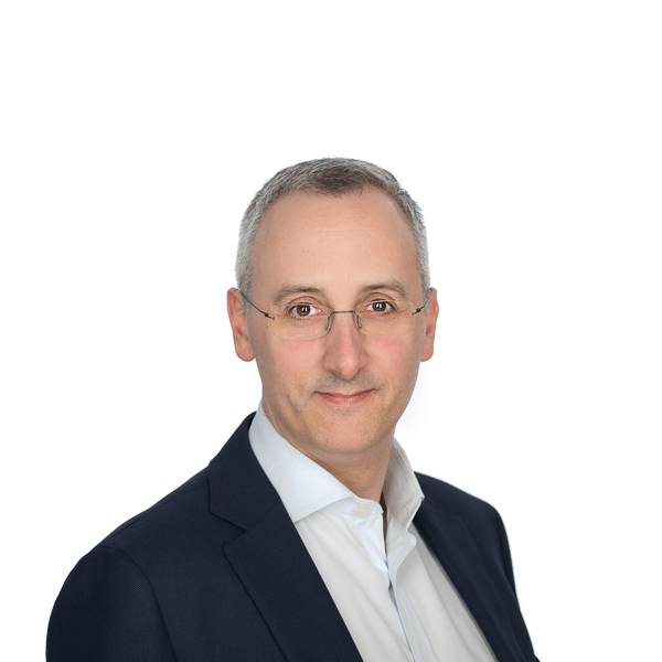 a man with gray hair in a black jacket and a white shirt smiles at the camera