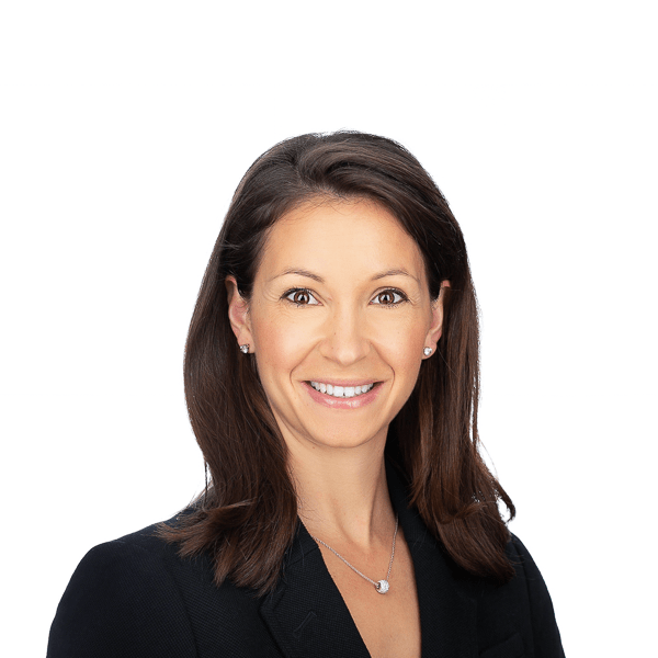 a woman with brown hair and brown eyes wearing a necklace in a black blouse smiles at the camera