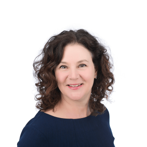 a woman with brown curly hair wearing a black blouse smiles at the camera