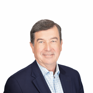 an elderly man in a navy blue suit smiles at the camera