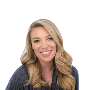 blond woman in gray sweater smiles at the camera