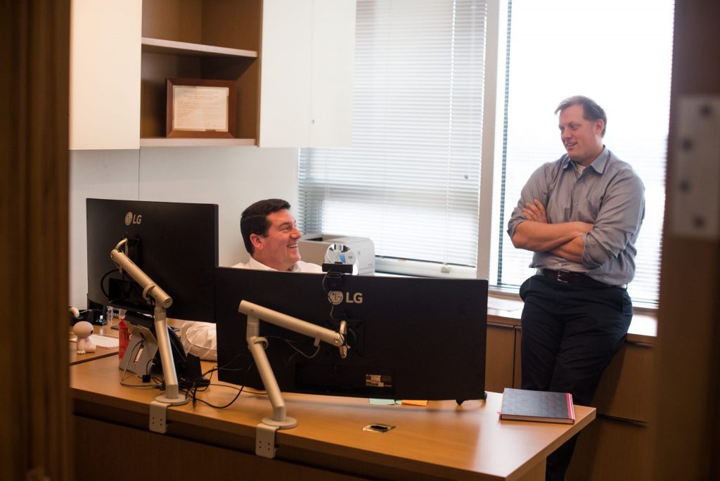 two men talking at the big screens from LG's computers