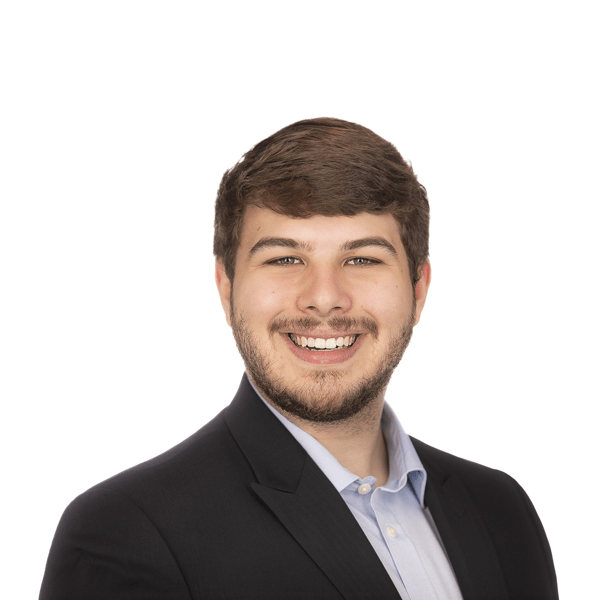 a man with a beard in a suit smiles at the camera