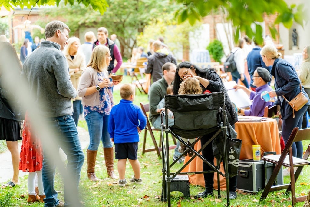 a woman at a picnic is painting children