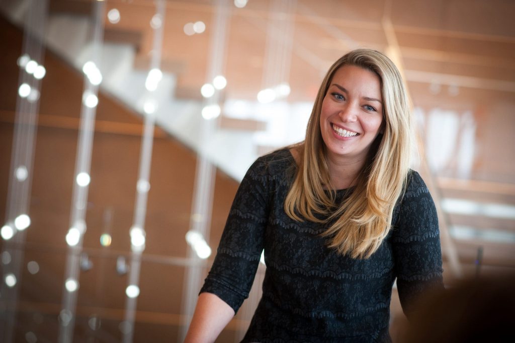blond woman standing near stairs smiling while chatting