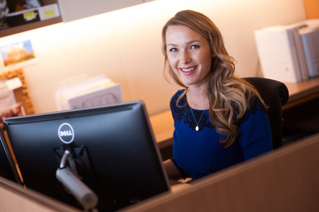 woman at work bench smiling at camera