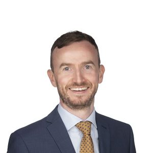 man in a tie smiling at the camera