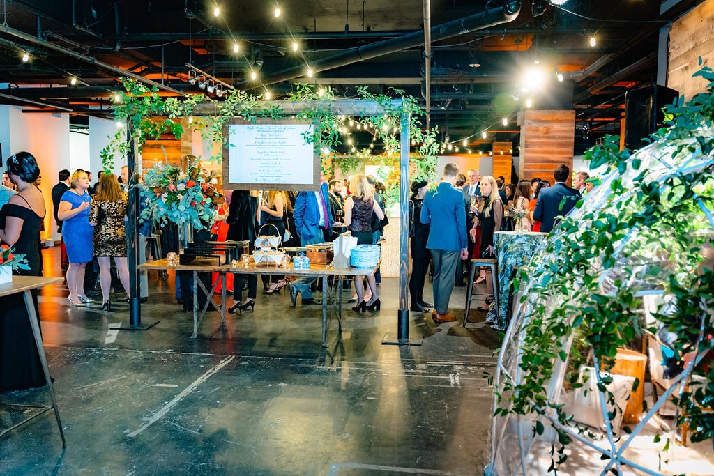 people at the meeting in an interior full of green vines