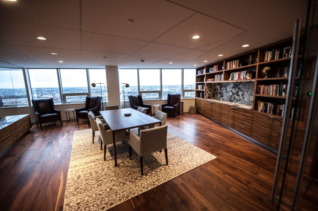 room with a bookcase and armchairs overlooking the city