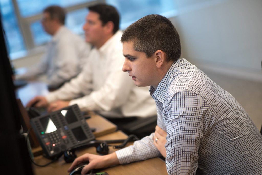 man in a checkered shirt works at the computer