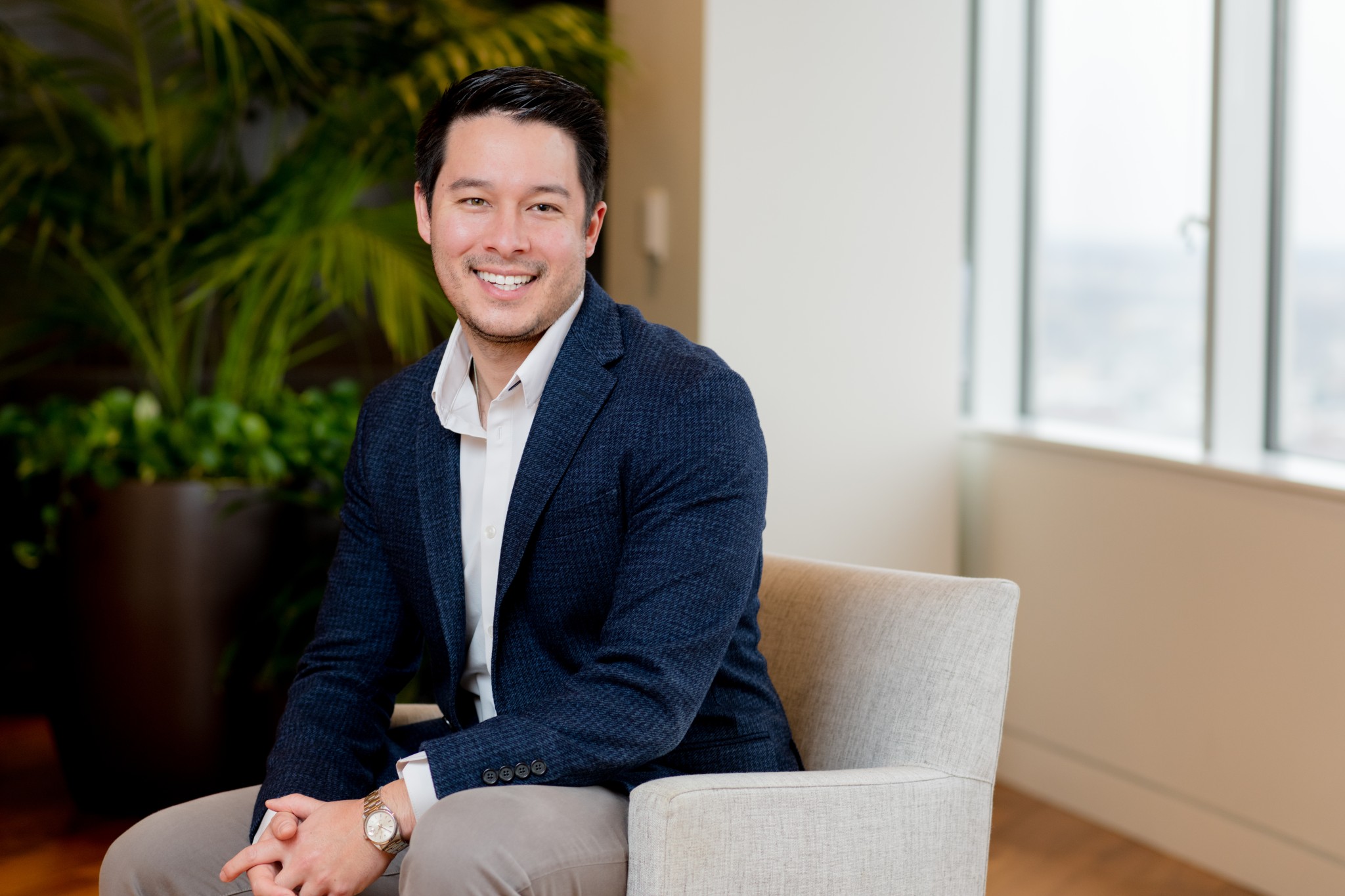 A smiling man sits in an armchair